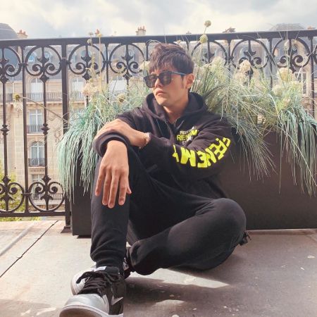 Jay Chou in a black hoodie poses for a picture.
